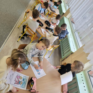 Dzieci siedzą przy stoliku i malują