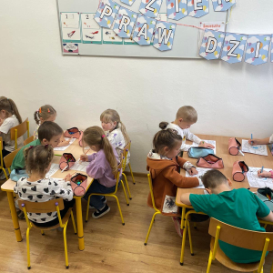 Dzieci siedzą przy stoliku i malują