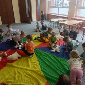 Dzieci układają misie na chuście