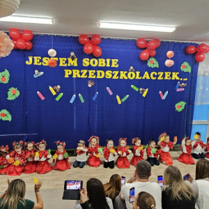 Dzieci siedzą i pokazują do słów muzyki