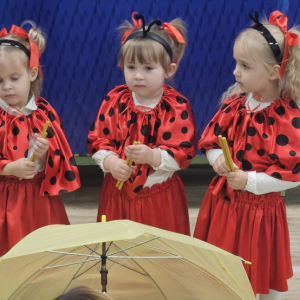 Dzieci uderzają kredkami w parasol