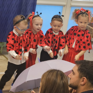 Dzieci uderzają kredkami w parasol