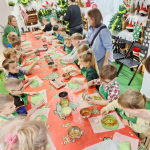 Dzieci kładą składniki na pizze.