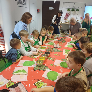 Dzieci kładą składniki na pizze.