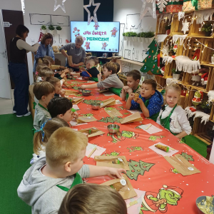 Dzieci ozdabiają choinki piernikowe jadalnymi mazakami.