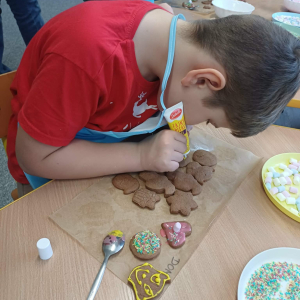 Chłopiec dekoruje pierniczki.