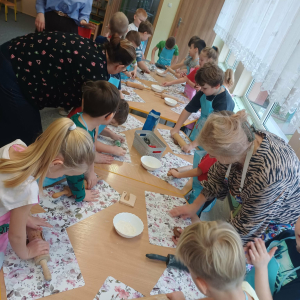 Dzieci gniotą ciasto na pierniczki.