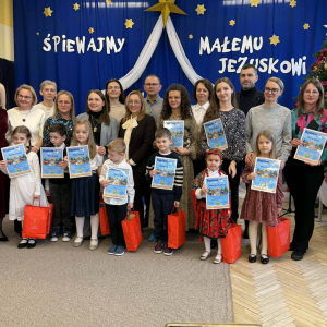 Mali artyści wraz ze swoimi opiekunami i Dyrektorkami stoją na scenie z dyplomami i nagrodami.