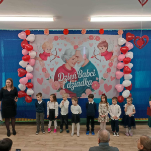 Dzieci i Panie stoją na tle dekoracji.