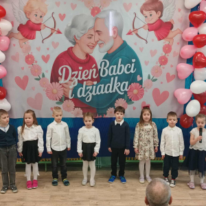 Dzieci stoją na tle dekoracji.