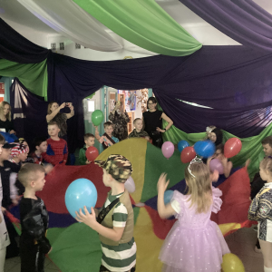 Dzieci bawią się przy muzyce podrzucając balony