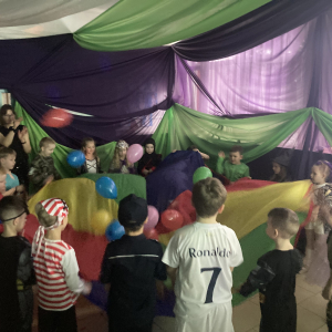 Dzieci bawią się przy muzyce podrzucając balony