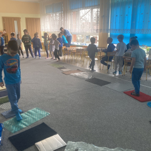 Dzieci przechodzą po ścieżce sensorycznej