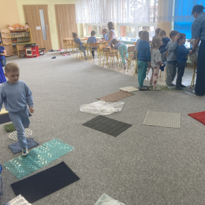 Dzieci przechodzą po ścieżce sensorycznej