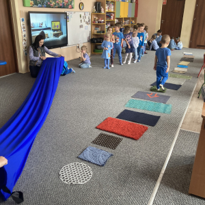 Dzieci przechodzą po ścieżce sensorycznej