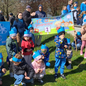 Dzieci stoją z banerem przedszkolnym