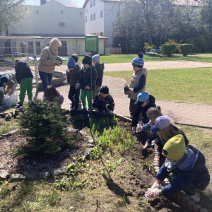 Dzieci sadzą kwiaty w ogródku