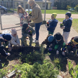 Dzieci sadzą kwiaty w ogródku