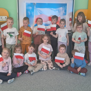 Krasnolódki trzymają flagi, które wykonały na zajęciach plastycznych