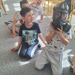 Chłopiec przymierza maskę przeciwgazową