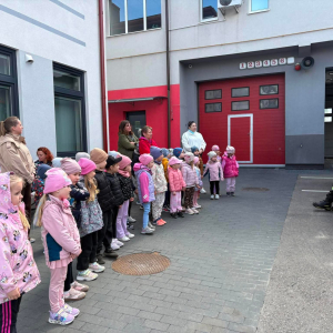 Dzieci na dworze oglądają wóz strażacki i cały sprzęt