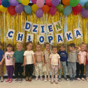 Zdjęcie grupowe dzieci. W tle dekoracja i balony.