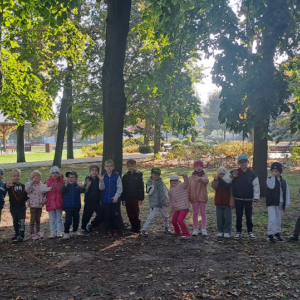 Dzieci stoją przed drzewem