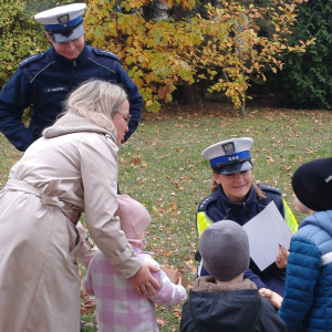 Dzieci wraz z panią wręczają podziękowanie policjantom