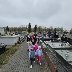 Dzieci idą aleją cmentarza