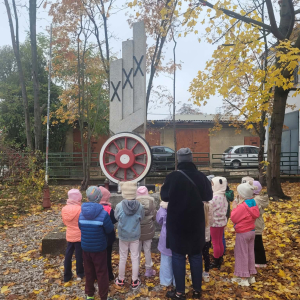 Dzieci modlą się przed pomnikiem kolejarzy. 